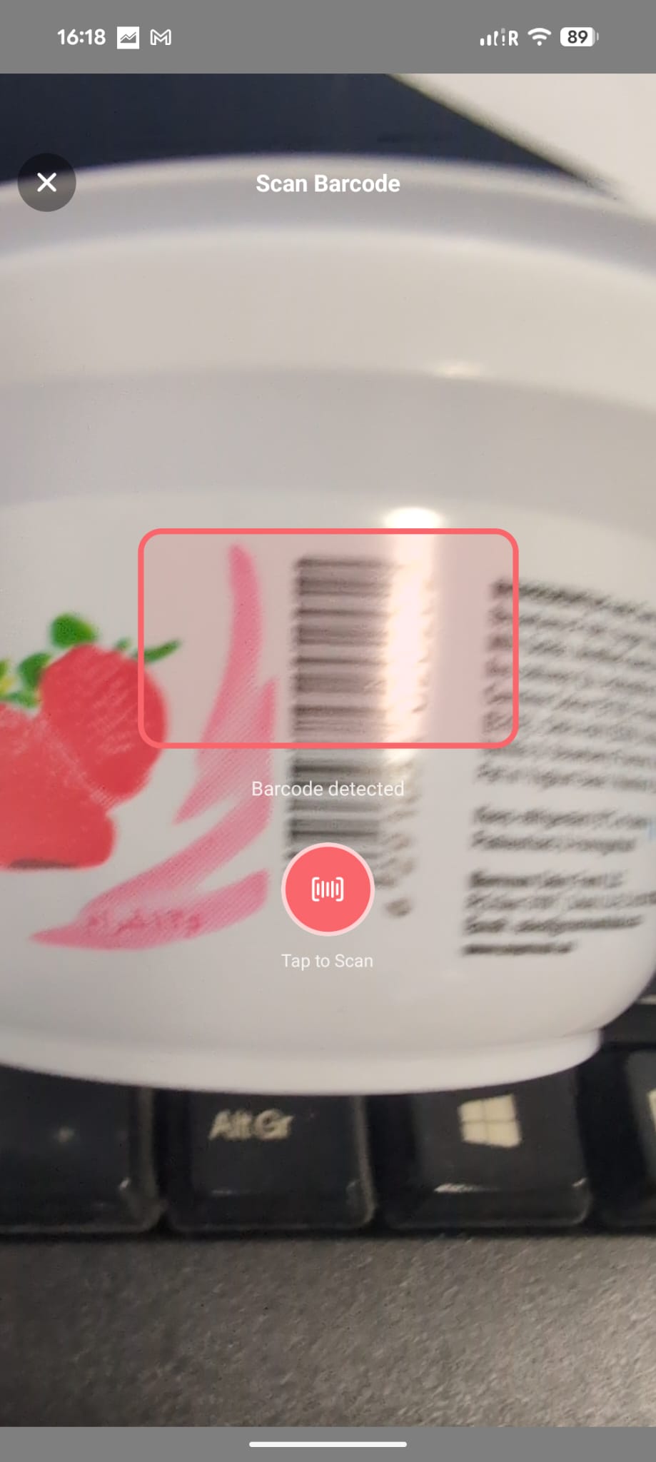 nYOOtrition Scan Barcode screen — coral guide frame around a detected barcode on a real product, with a Tap to Scan button